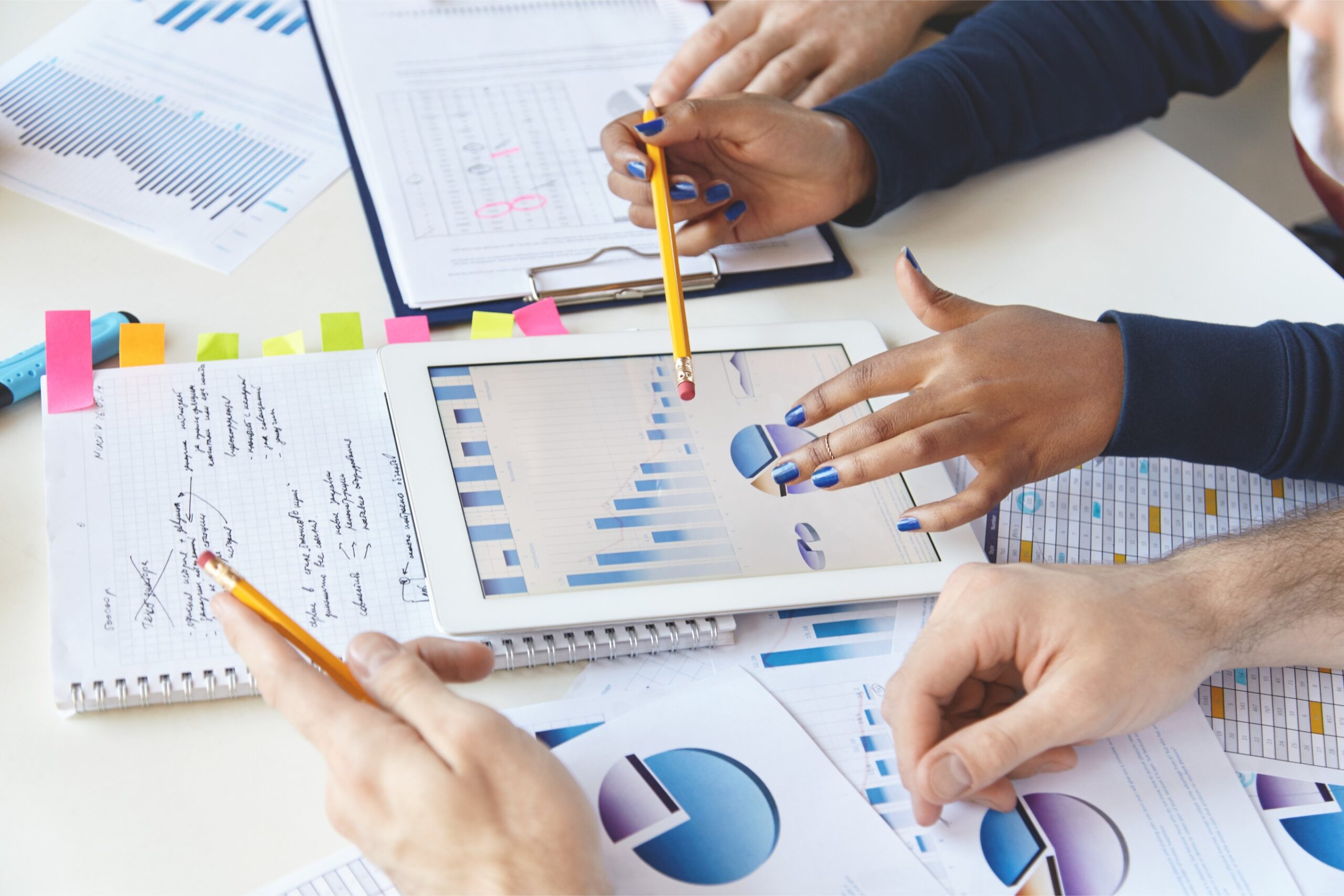 colleagues-working-together-financial-report-using-modern-gadget