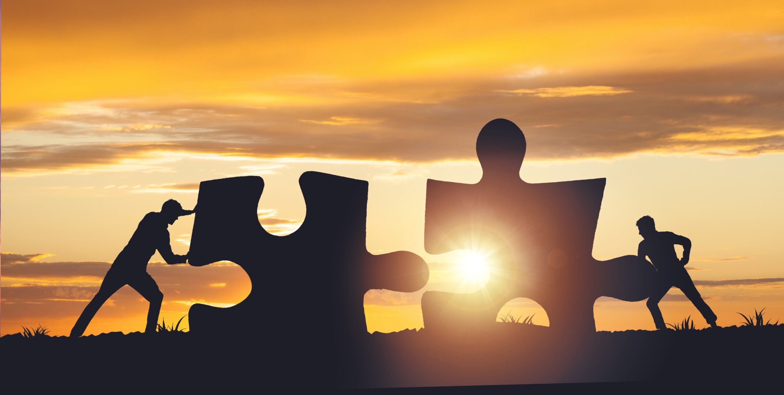 silhouette-team-folding-puzzle-against-sunset-background-business-teamwork-concept